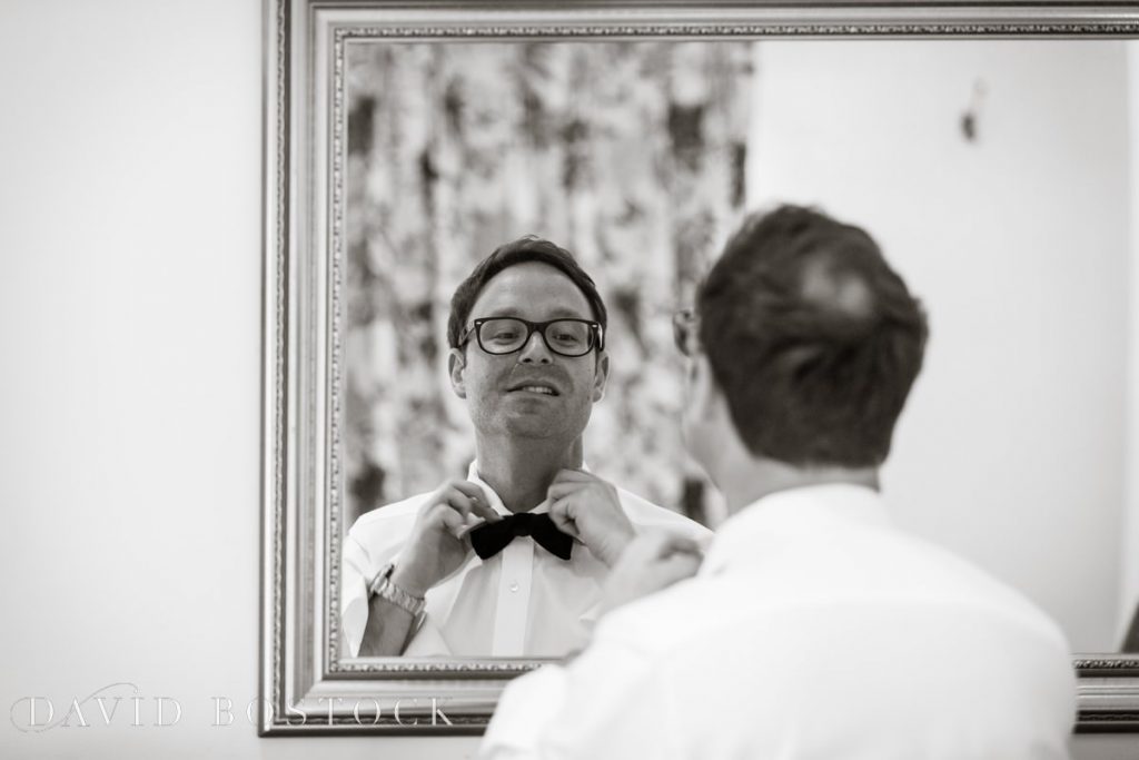 groom tying bow tie