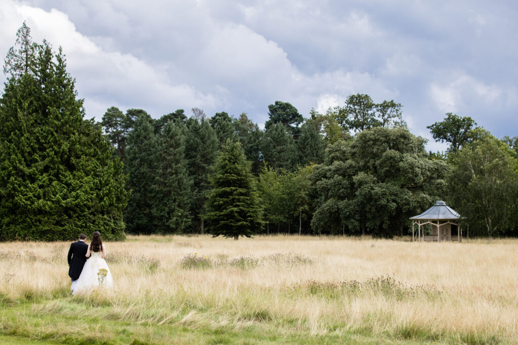 Hedsor House wedding couple walking in field