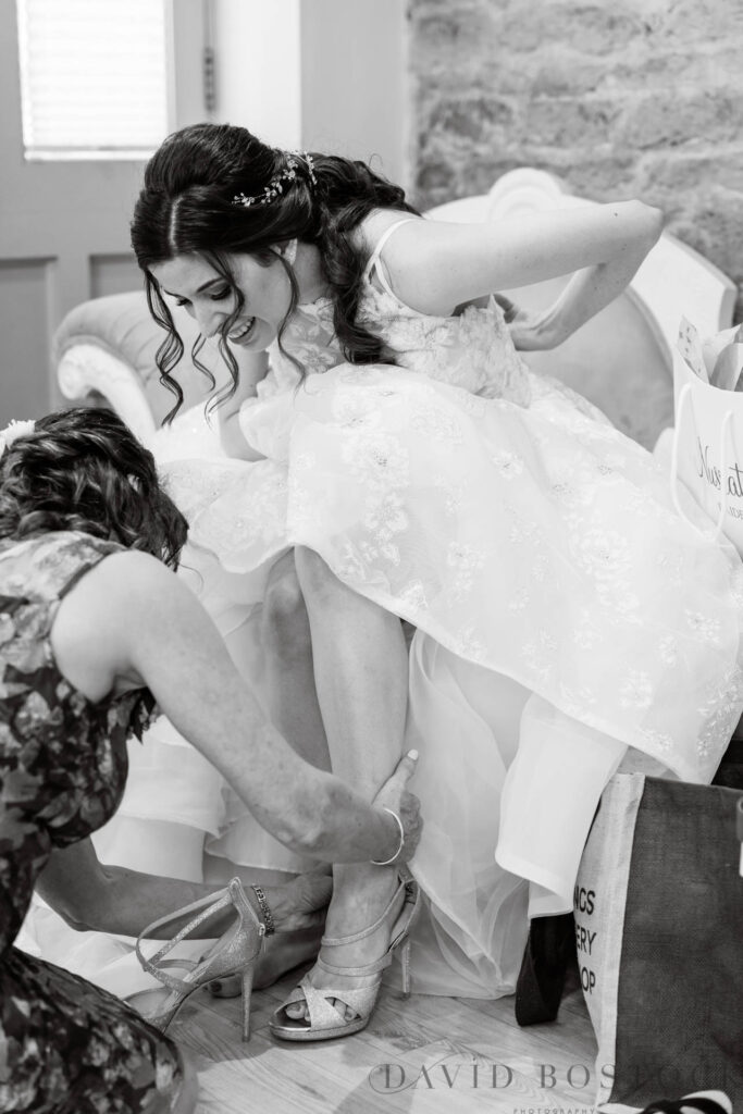 The Great Barn wedding bride putting on shoes