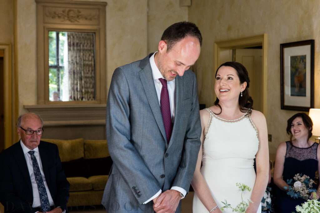 bride smiling at groom during vows at Le Manoir Aux Quat'Saisons