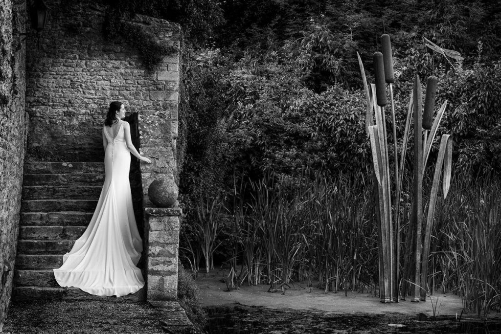 wedding photography fellowship image -wedding photography fellowship image -Bride standing on the stone steps next to the water at Le Manor