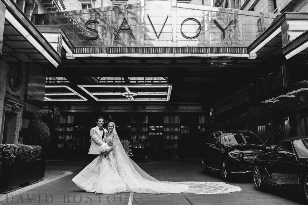 bride and groom kissing outside the savoy hotel london
