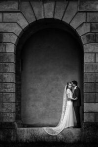 bride and groom underneath the stone arches at Cliveden