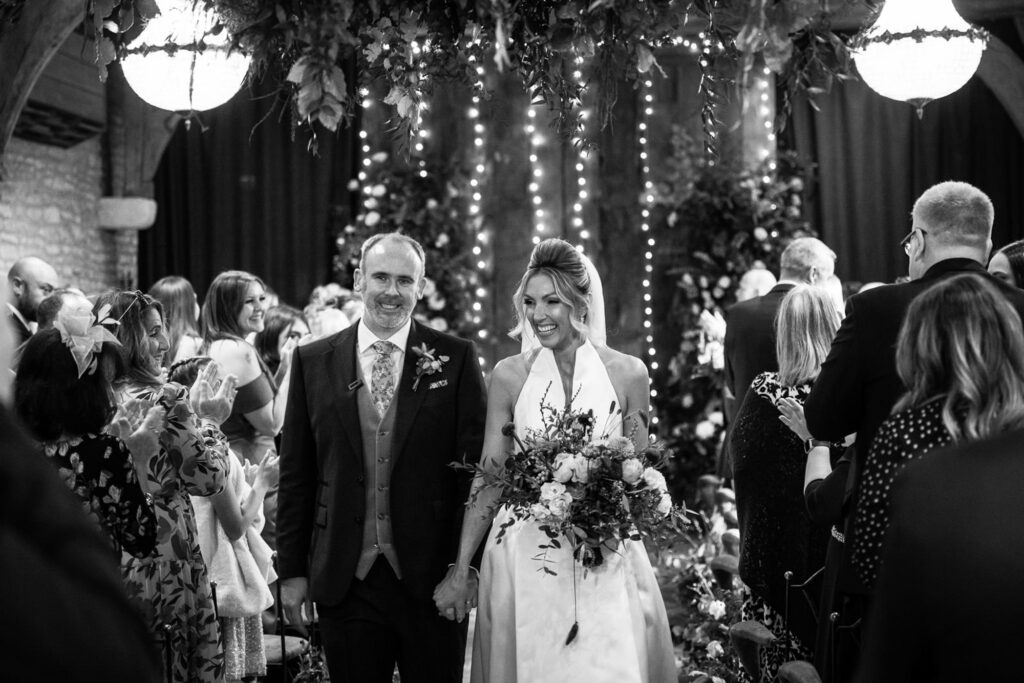 bride and groom just married walking down aisle