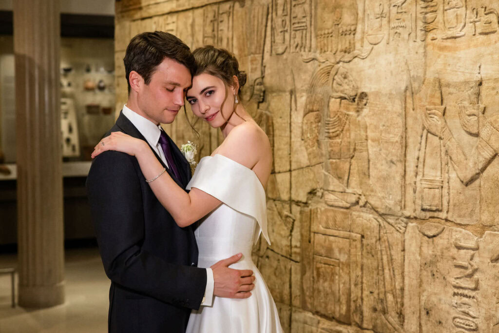 Newlyweds embracing inside Oxford's Ashmolean Museum