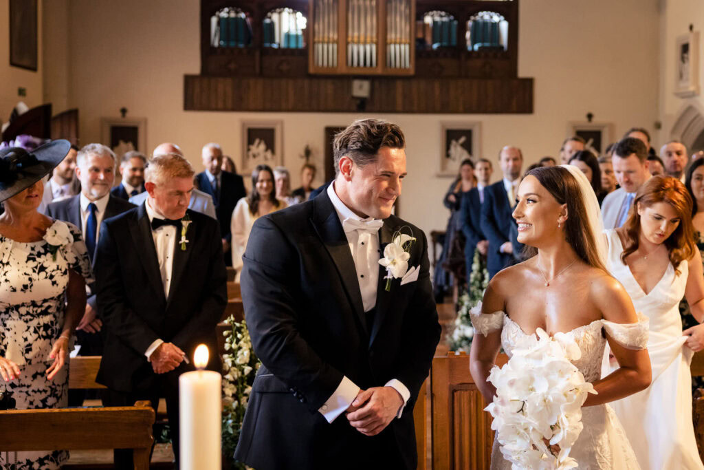 bride and groom smiling inside church