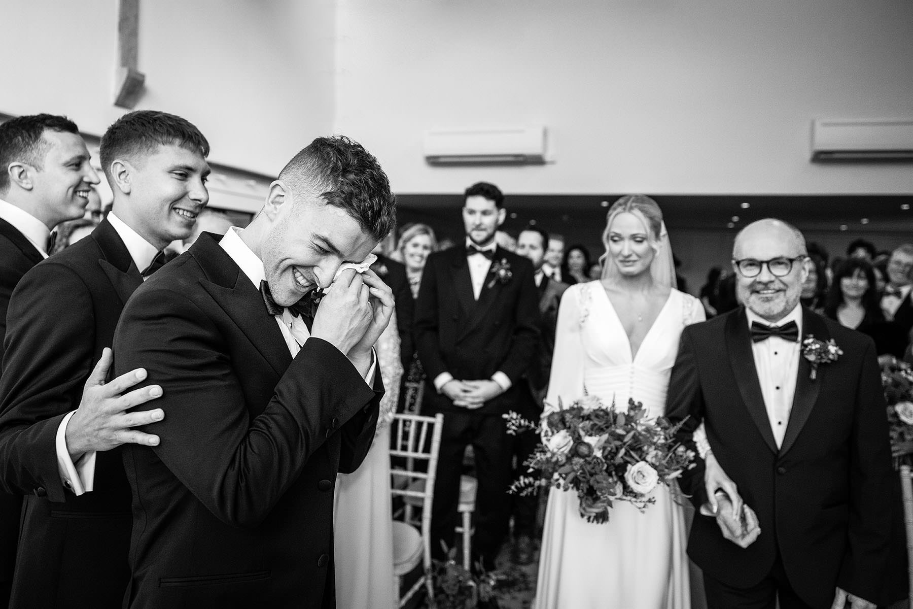 grrom shed tear as bride walks down the aisle on their wedding day