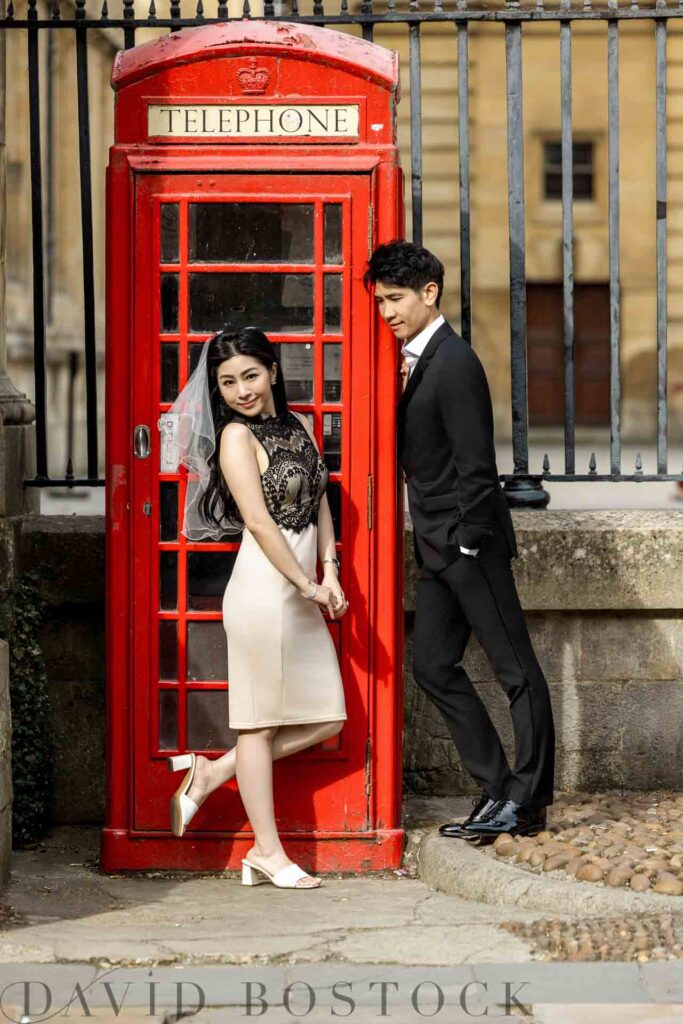 Asian bride to be and groom to be by red telephone box in Oxford