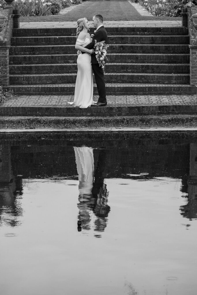 bride and groom with reflection in pond